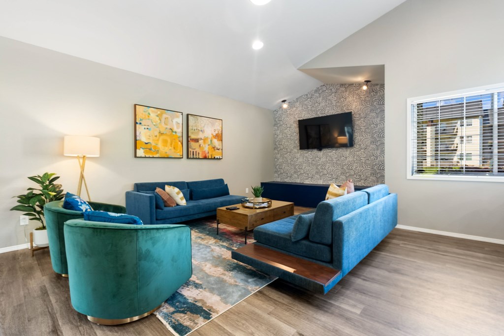 A living room with blue couches and a fireplace.