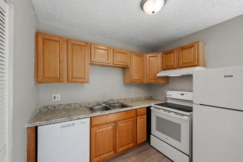 a kitchen with white appliances and wooden cabinets