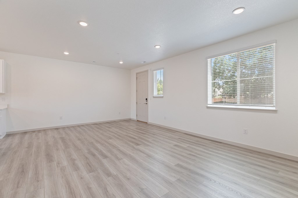 an empty living room with white walls and a window