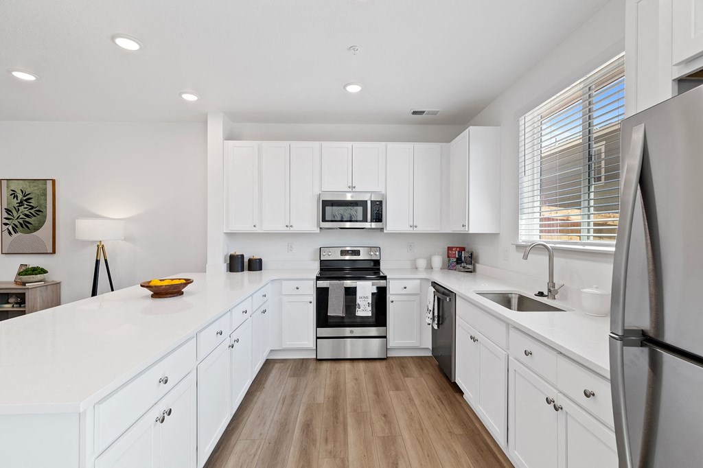 a large white kitchen with white cabinets and stainless steel appliances