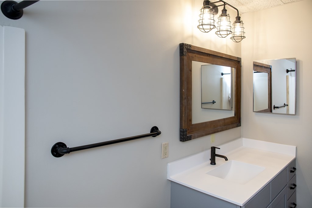 A bathroom with a white sink and a mirror above it.