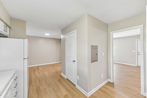 A kitchen with a white refrigerator and wooden floors.