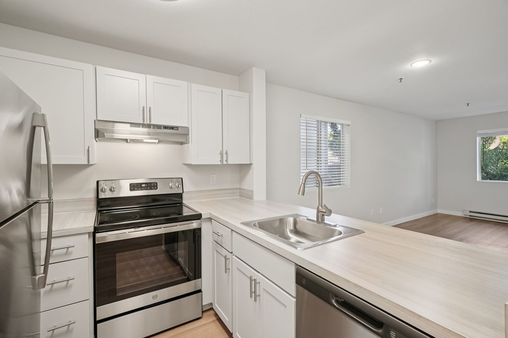 A modern kitchen with stainless steel appliances and white cabinets.