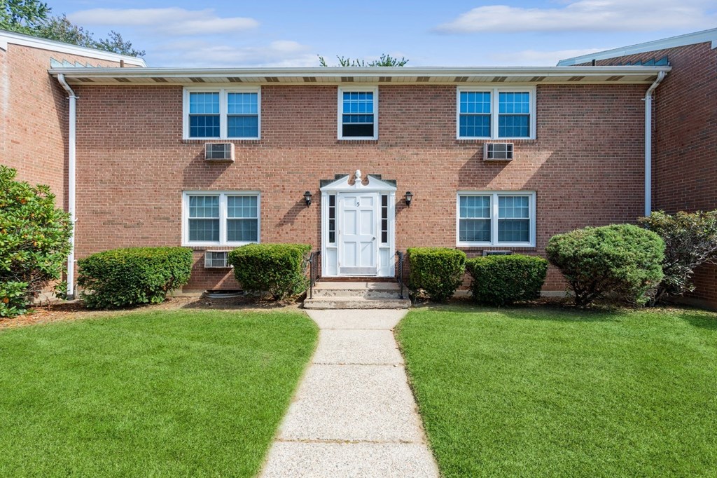 the front of a brick house with a white front door
