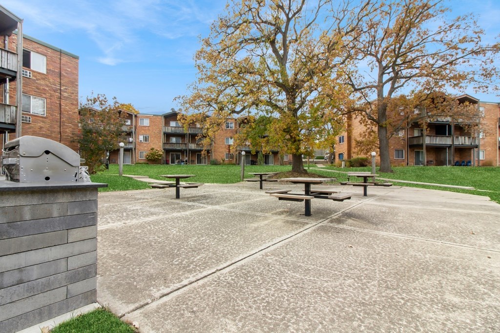 an empty park with benches in front of a building at River Oaks, Illinois