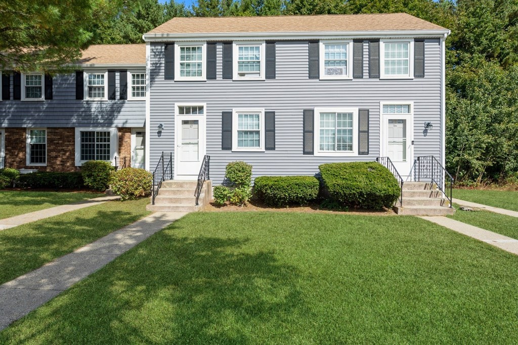 the front of the apartments with a lawn and a pathway at Arbor Commons