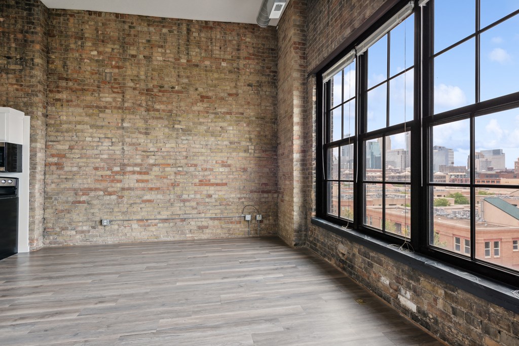 an empty room with large windows and a wooden floorat Gaar Scott Historic Lofts, Minnesota, 55401