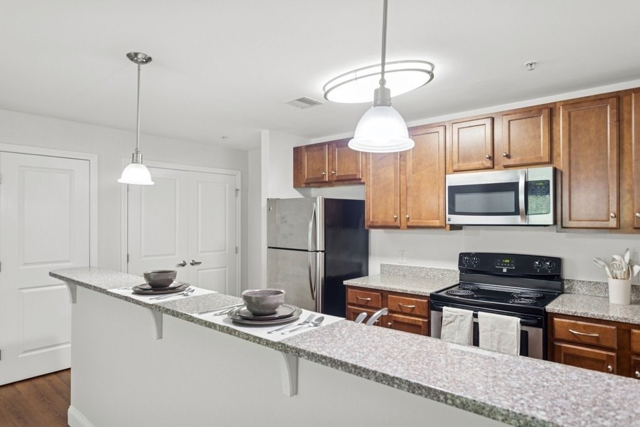 A kitchen with wooden cabinets and a black refrigerator.