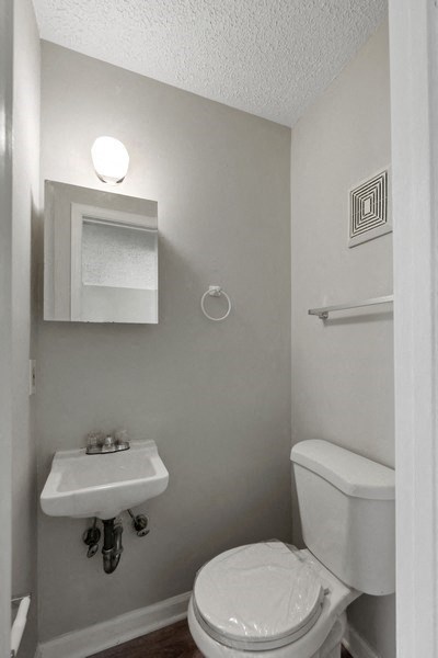 a bathroom with a toilet sink and mirror at Fort Collier Terrace, Virginia