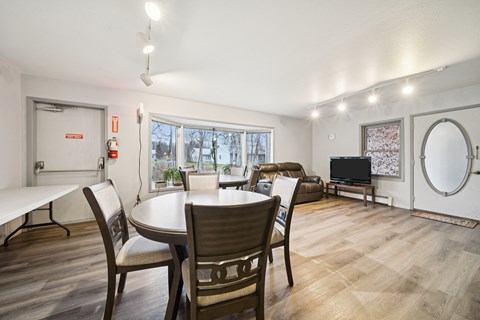 A dining room with a table and chairs.