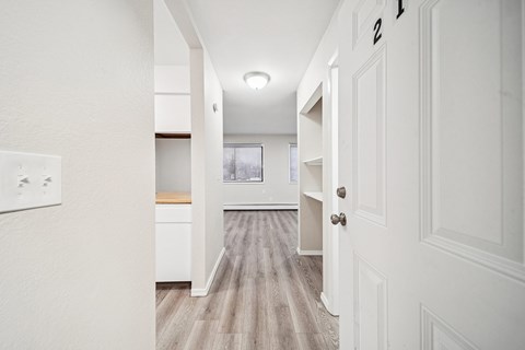 A hallway with a white door on the right and a number 2 on the door.