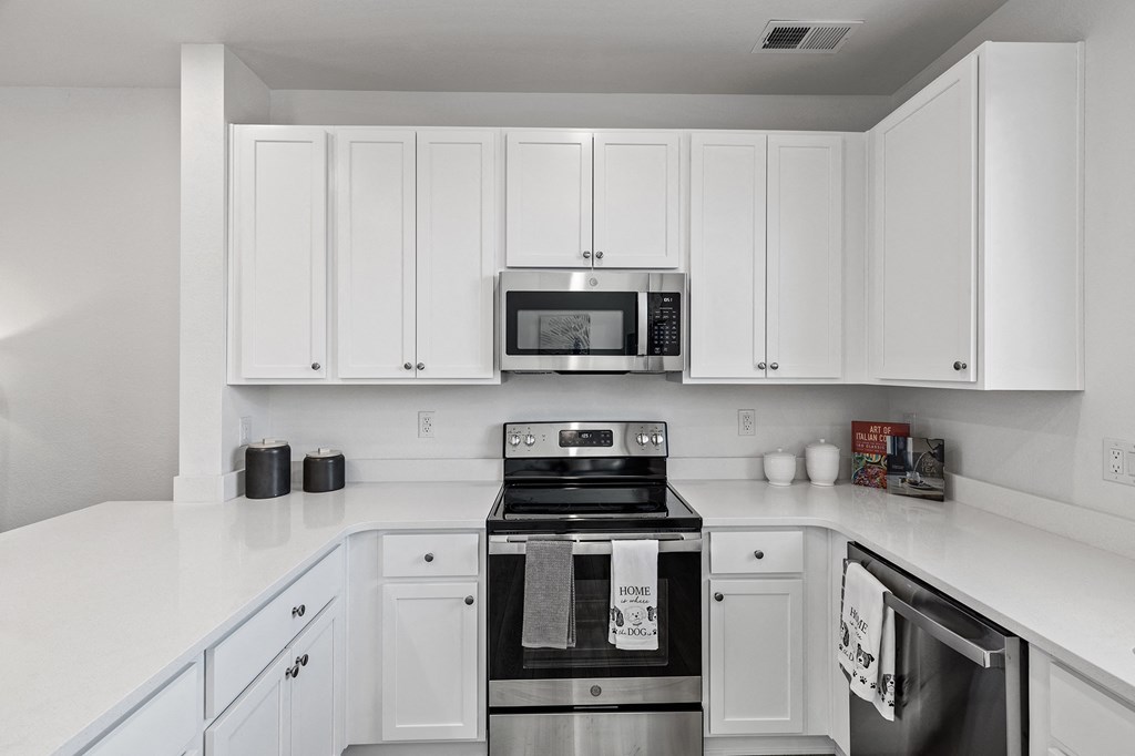 a kitchen with white cabinets and stainless steel appliances