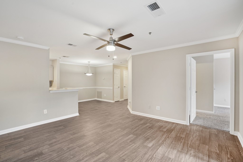 A living room with a ceiling fan and light fixture.