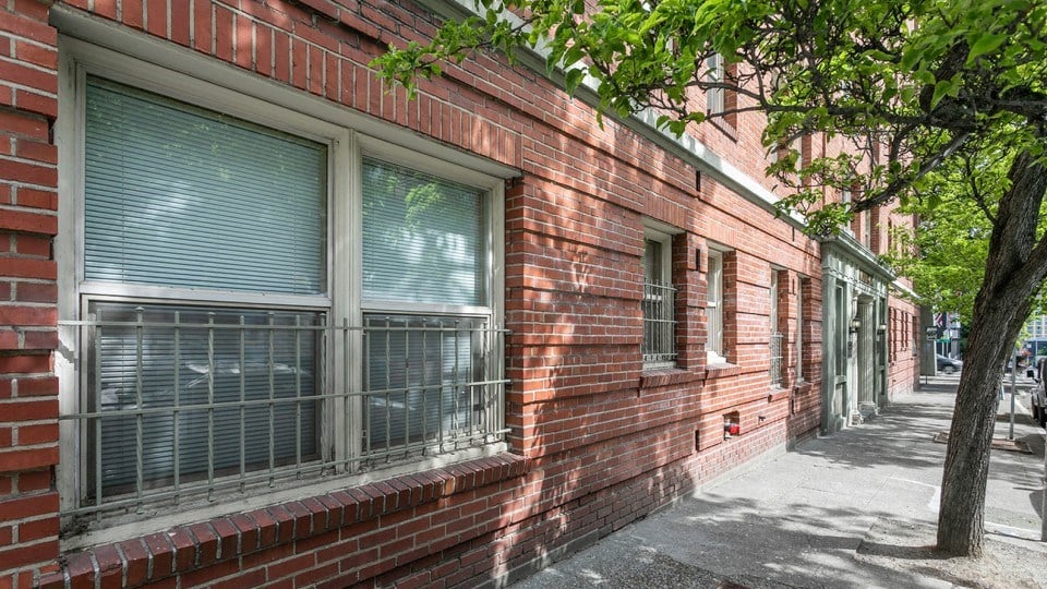 a red brick building with windows and a sidewalk