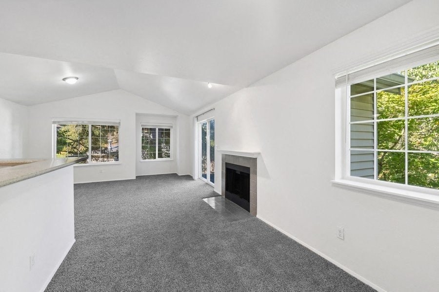 the living room and kitchen of a house with a fireplace