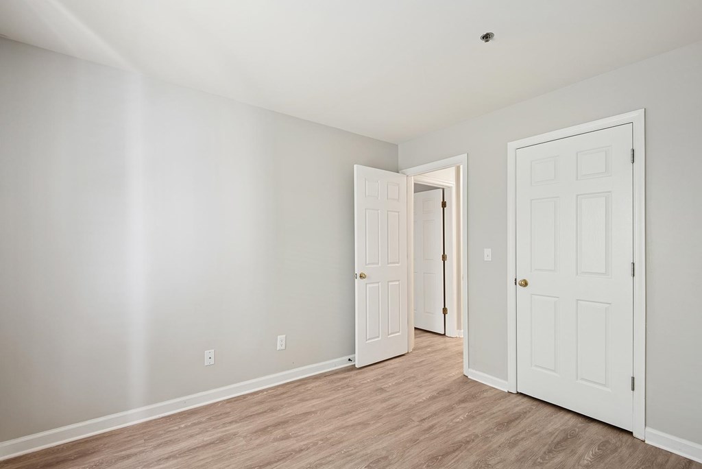 A room with two doors and a wooden floor.