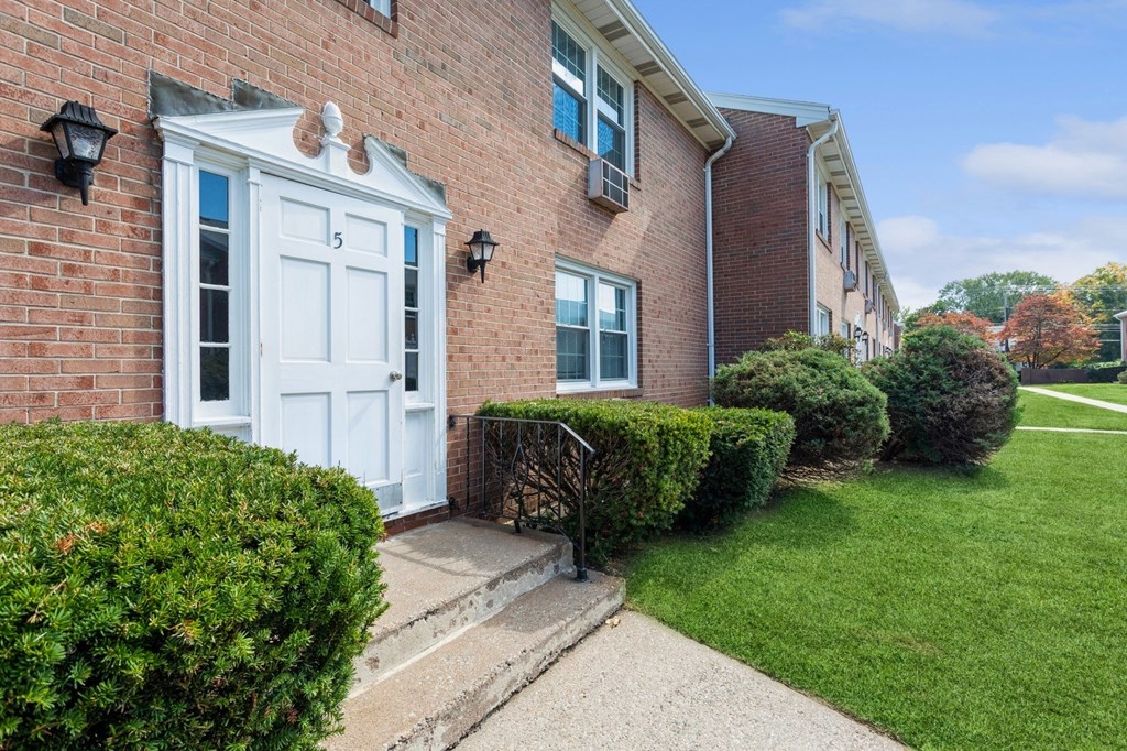 the front of a brick apartment with a white door