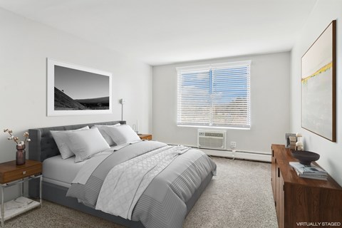 A bedroom with a large bed and a painting on the wall.
