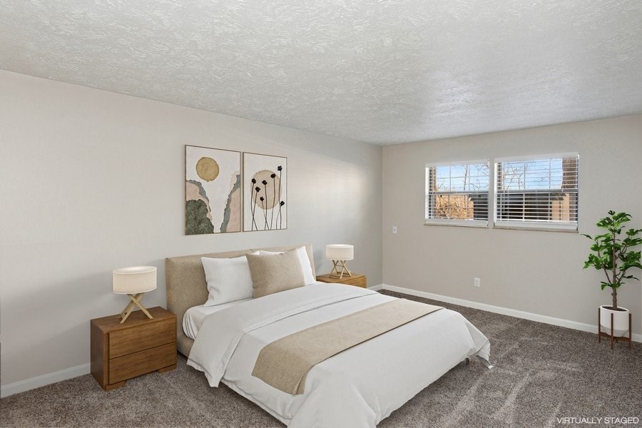 A bedroom with a large bed and two lamps.