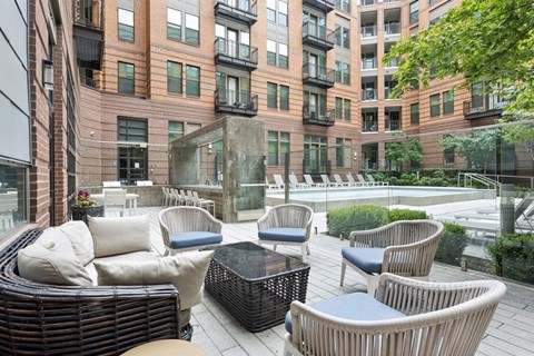 a patio with chairs and a table in front of a building