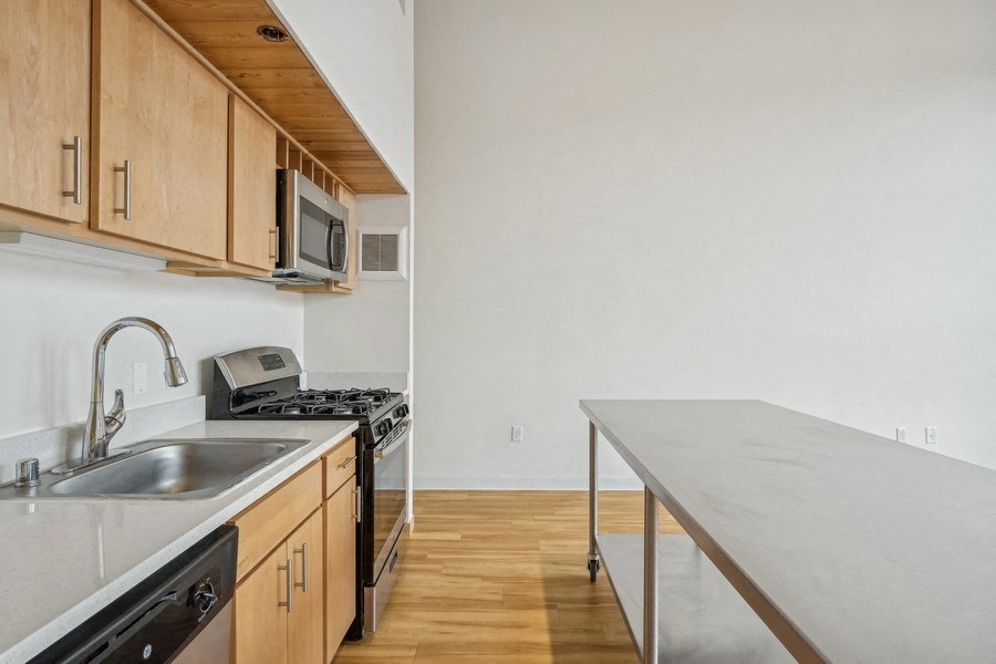 A kitchen with wooden cabinets and a stainless steel sink.