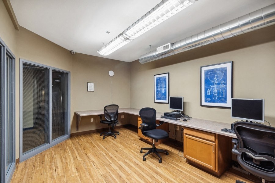 an office with two desks and two computer monitors