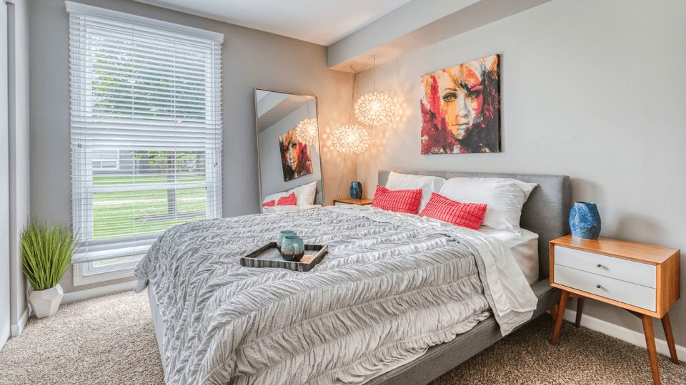 a bedroom with a large bed and a large window at The View Apartments St Charles, Illinois