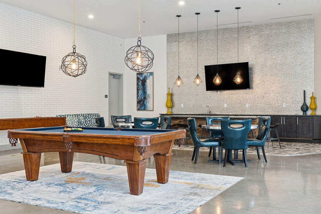 A room with a pool table and a television mounted on the wall.