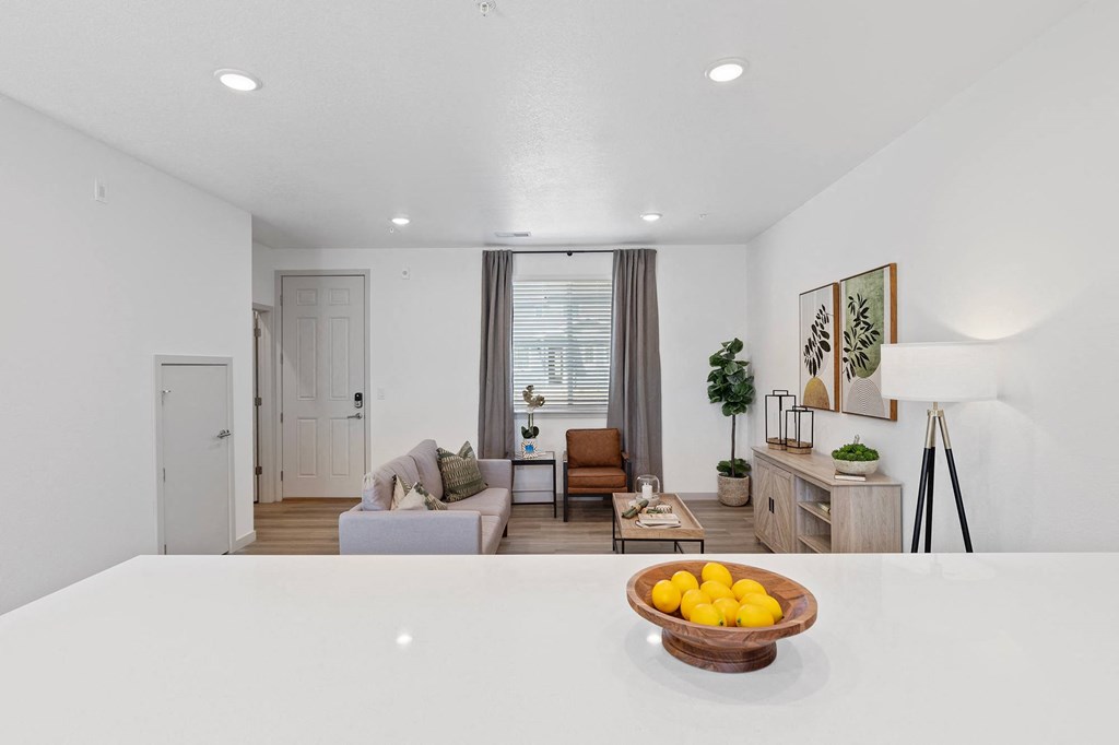 a white kitchen with a bowl of fruit on the counter