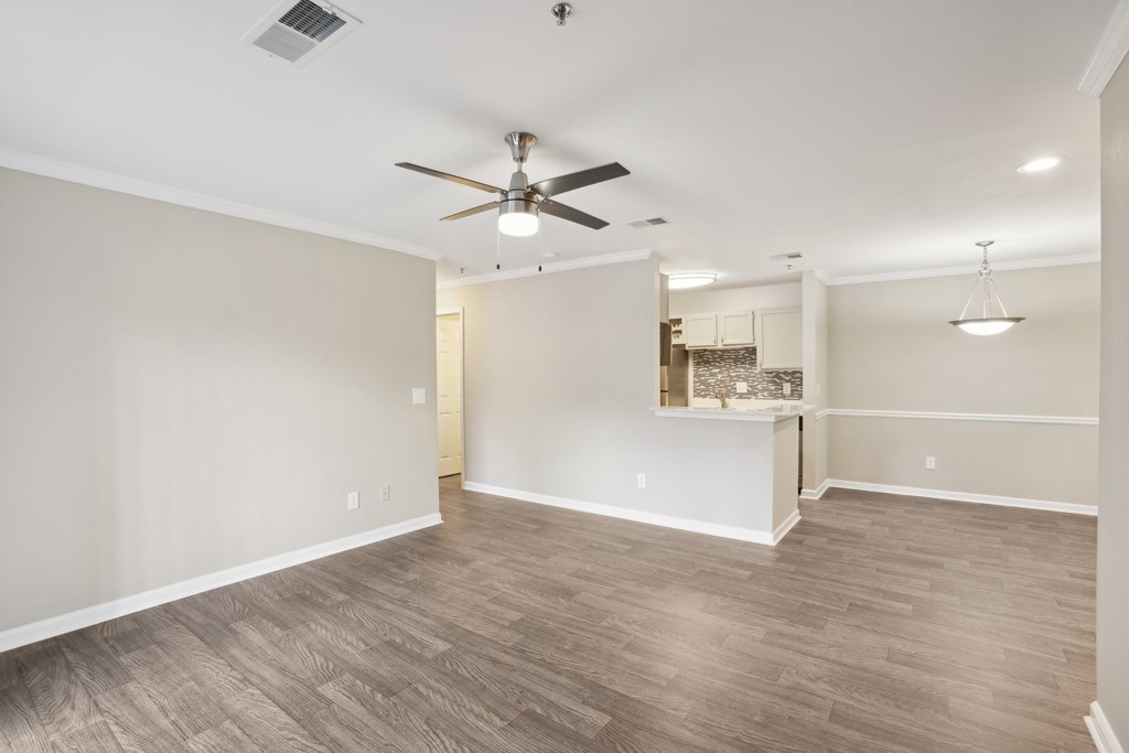 A living room with a ceiling fan and lighting fixture.