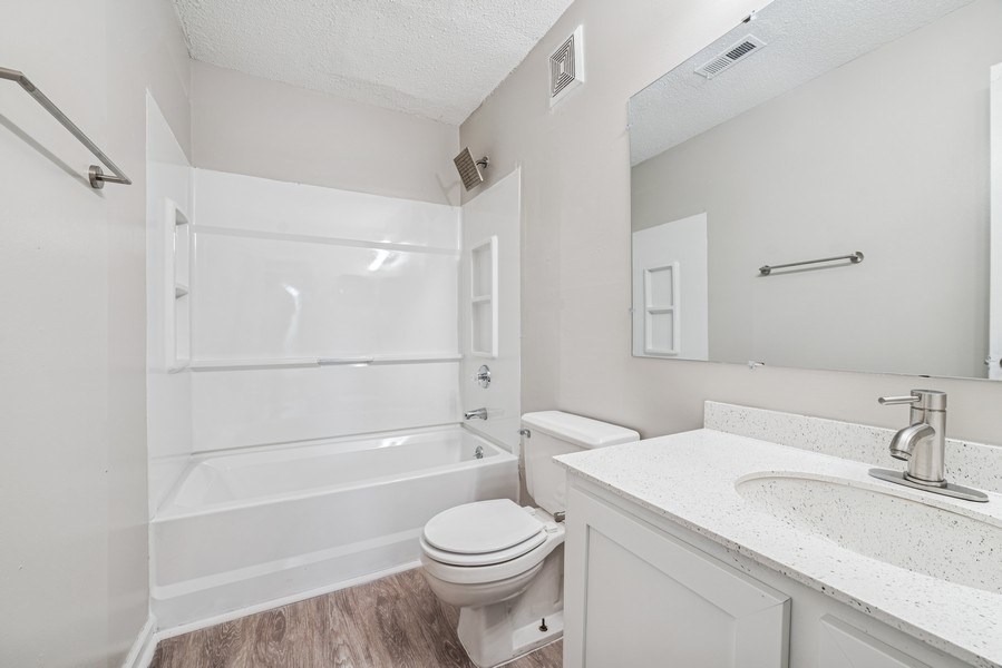 A white bathroom with a toilet, sink, and bathtub.