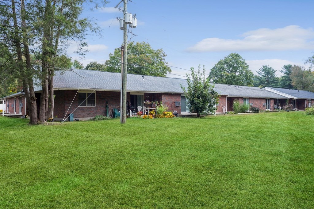 a view of the front of a brick house with a green yard