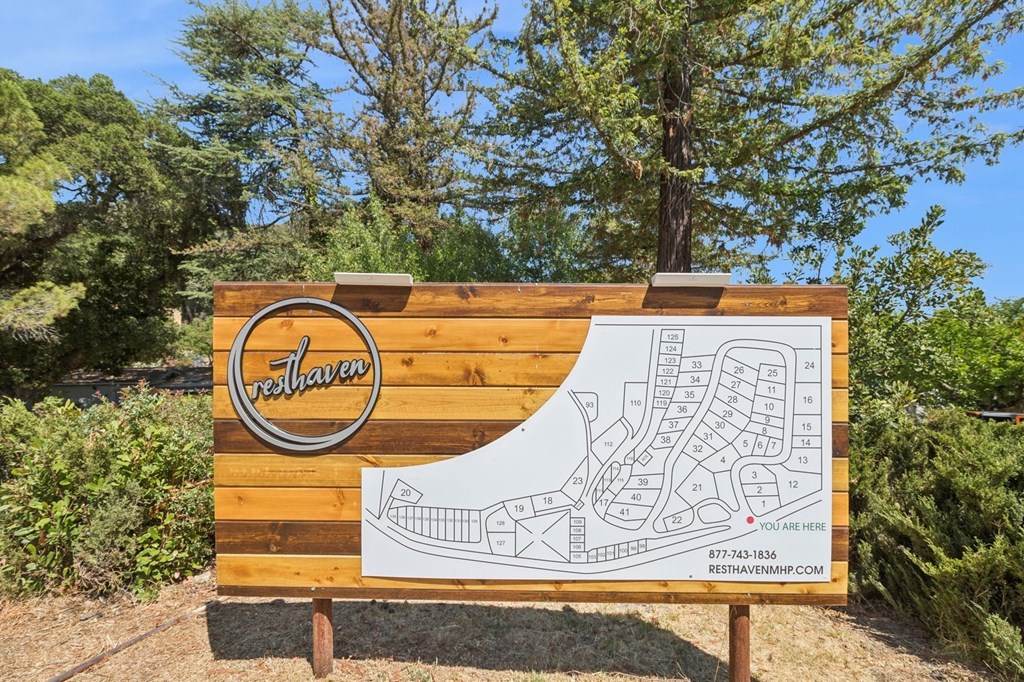 A wooden sign for a place called "rethaven" with a shoe-shaped maze on it.