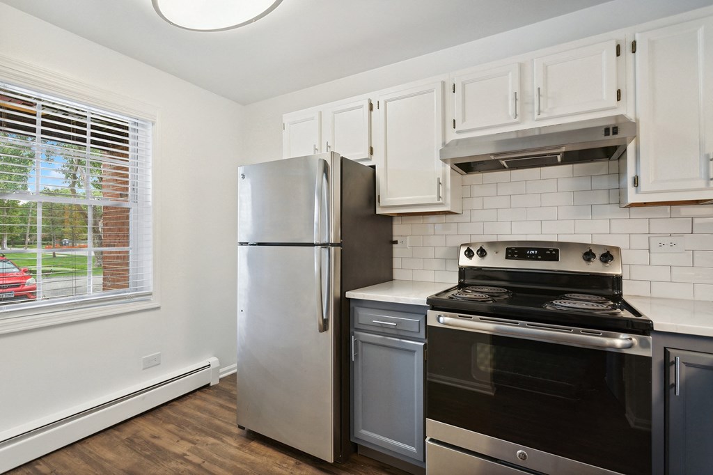 a kitchen with white cabinets and stainless steel appliances at The Hinsdale, Illinois, 60521