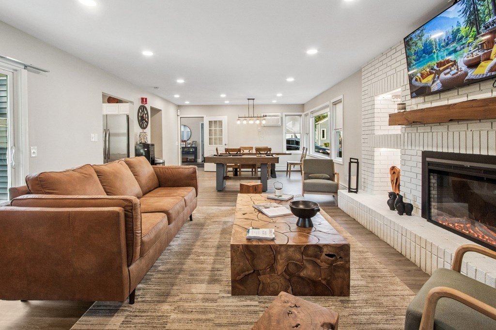 A living room with a fireplace and a television mounted on the wall.