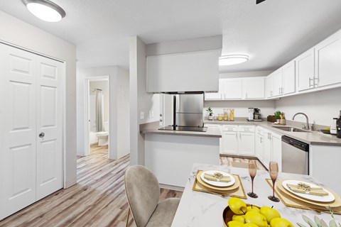 A modern kitchen with a dining table set for two.