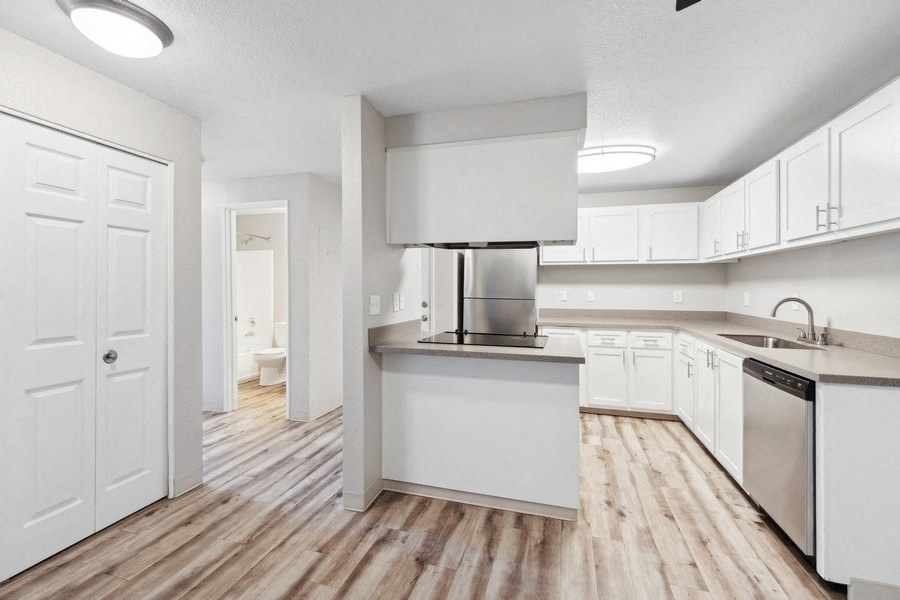 a large white kitchen with white cabinets and stainless steel appliances at Sundial Apartments, Wilsonvile, Oregon
