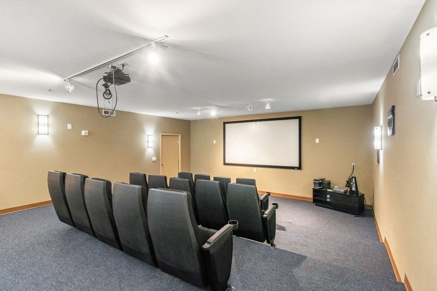 a theater room with a projector screen and chairs
