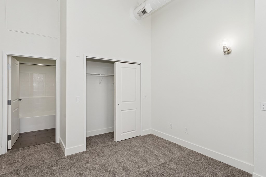 A room with two open doors and a carpeted floor.