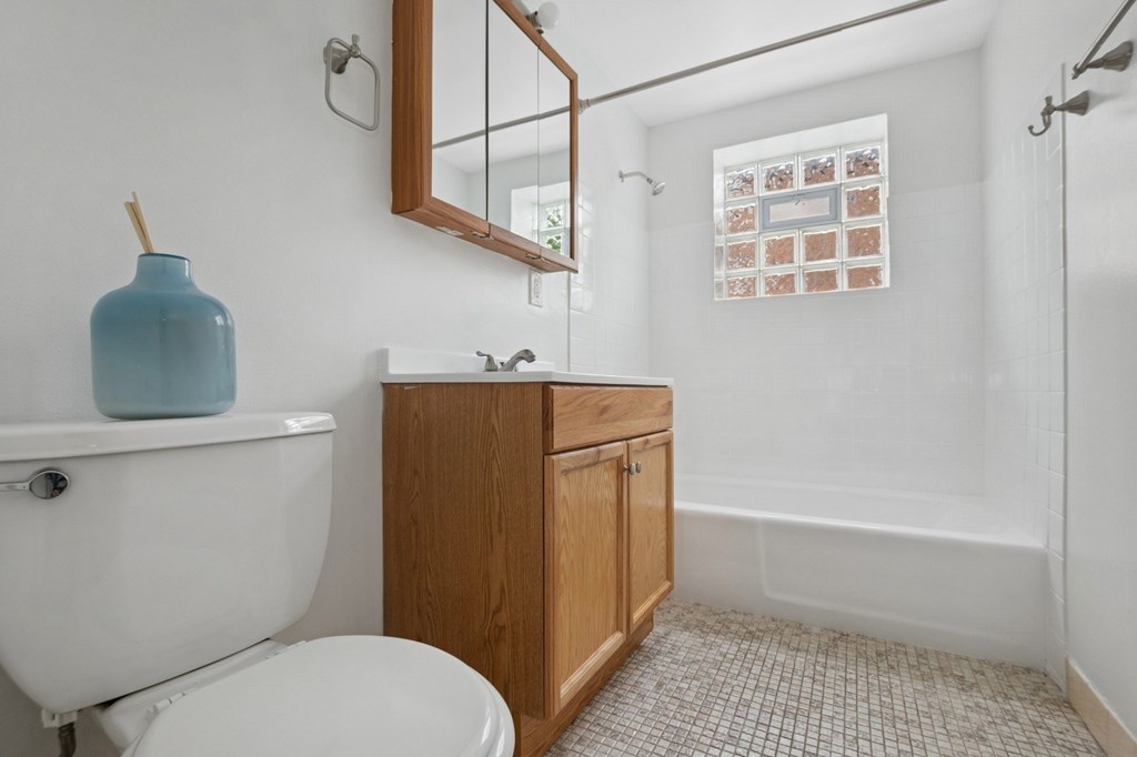 A white toilet sits next to a sink in a small bathroom.