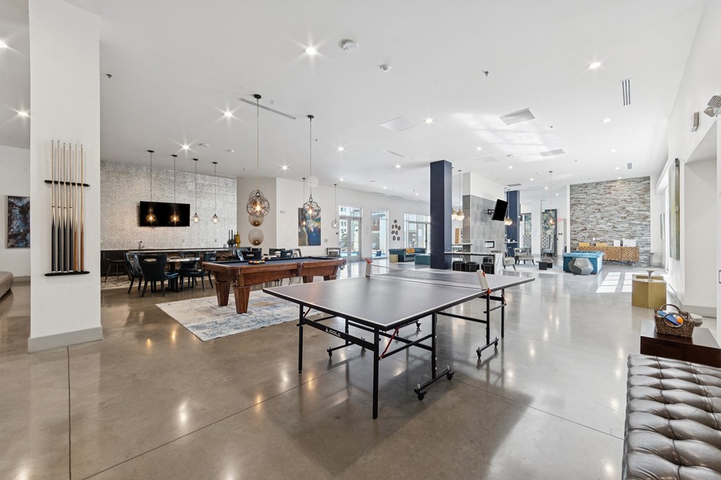 A spacious room with a pool table and table tennis setup
