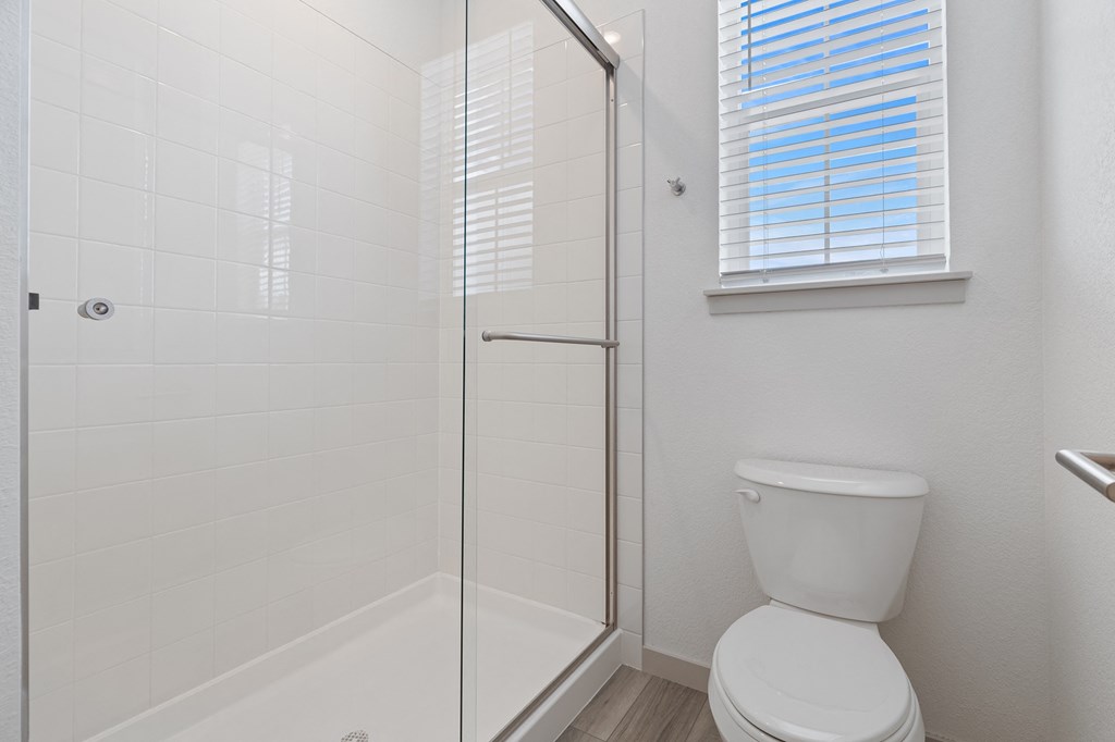 a white bathroom with a shower and a toilet