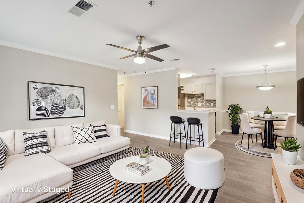 A living room with a white couch, a coffee table, and a ceiling fan.