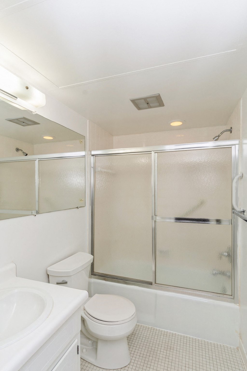 A white toilet and sink in a small bathroom.