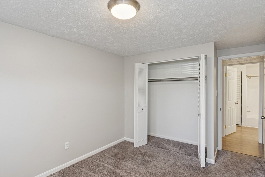 A room with a carpeted floor and a sliding door.