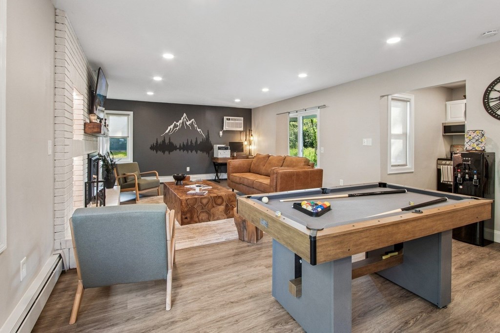 A room with a pool table and a couch.
