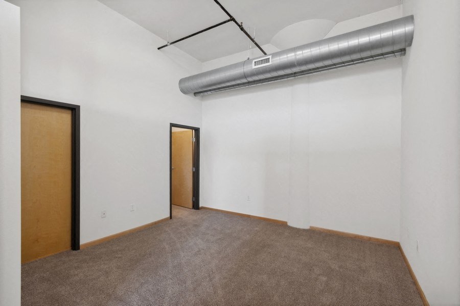 an empty living room with white walls and a door to a hallway
