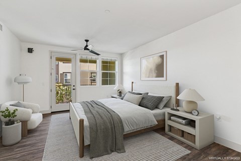 A bedroom with a large bed and a ceiling fan.