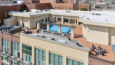 A rooftop with a pool and loungers.