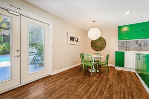 a dining room with a table and chairs and a large window